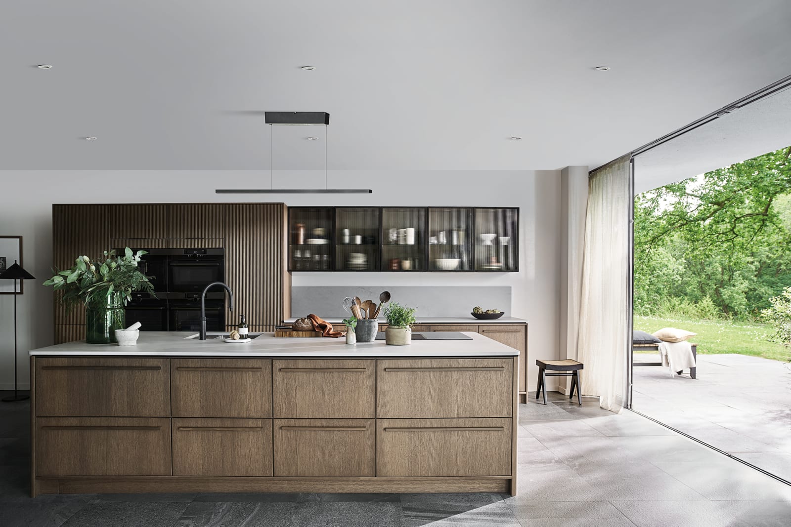 Magnet Kitchens 2021 Nordic Nature range with Fluted oak cabinets with Dekton Aeri worktop. Floating island with boiling hot water tap.
